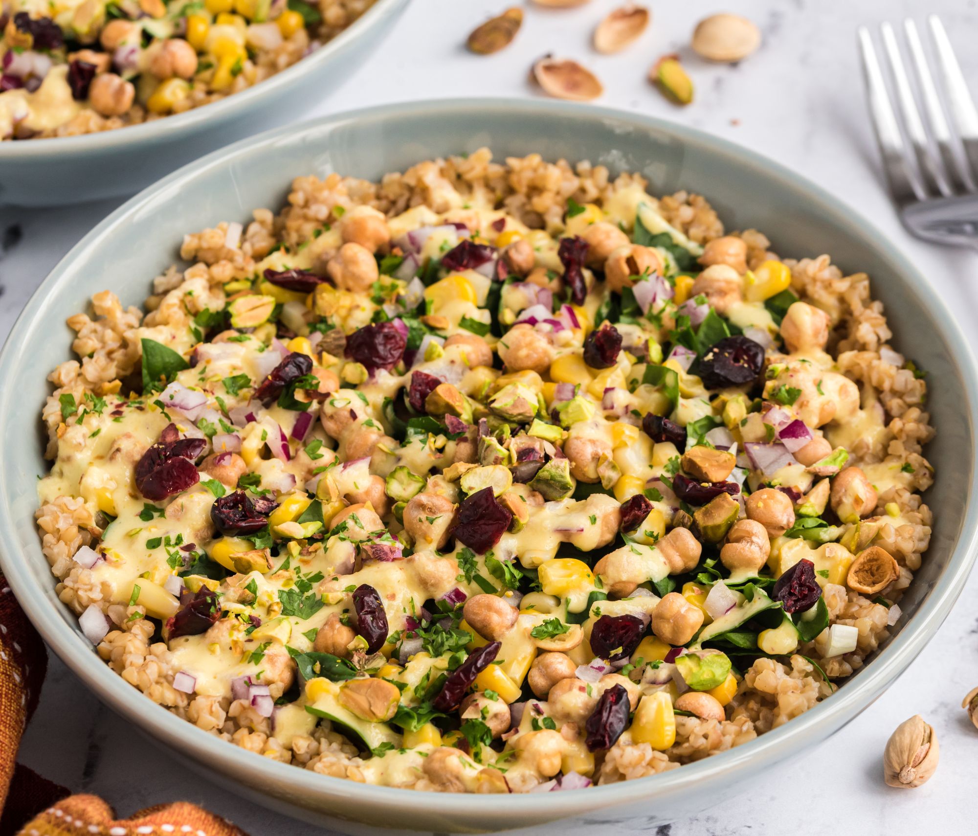 Moroccan Bulgur Bowl with Savory Orange Dressing in a white bowl on top of a table